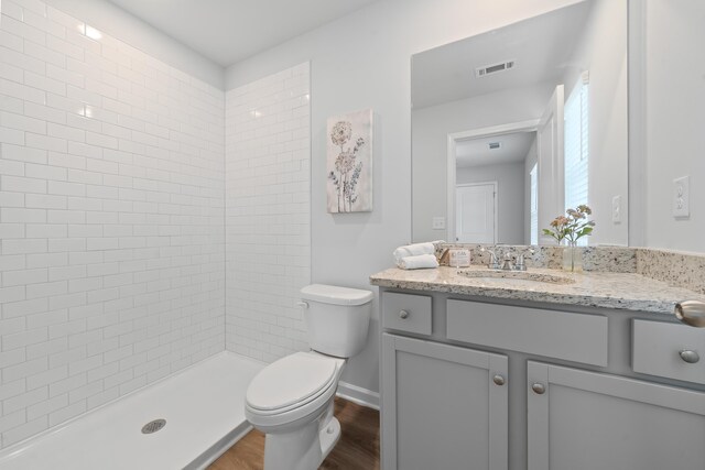 100 Lena Ln, Eatonton, GA 31024 - bathroom featuring visible vents, toilet, wood finished floors, vanity, and tiled shower