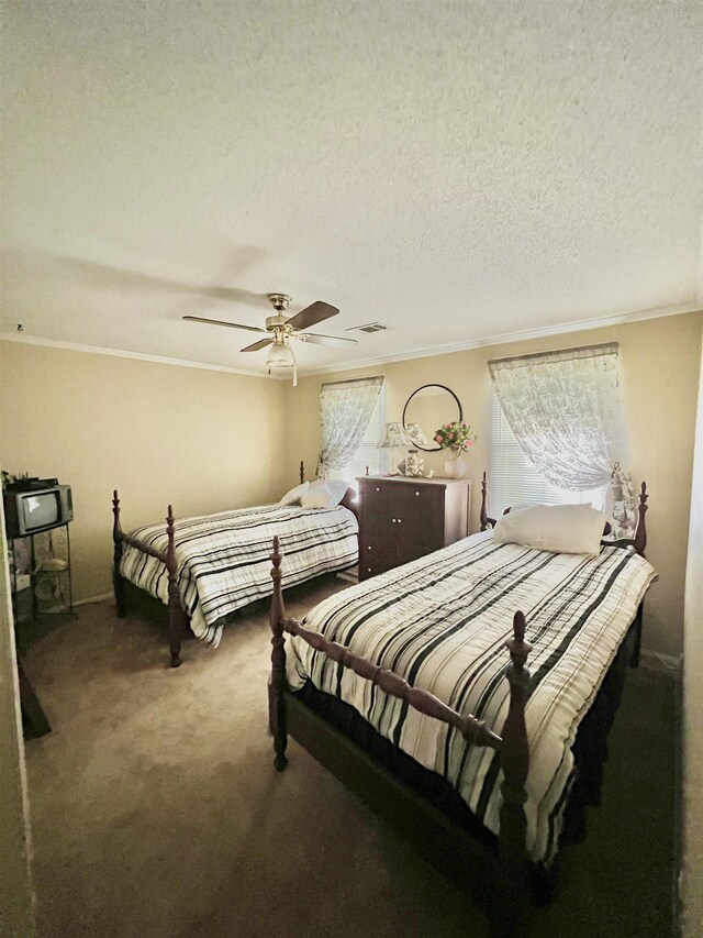 bedroom with ornamental molding, carpet floors, and a textured ceiling