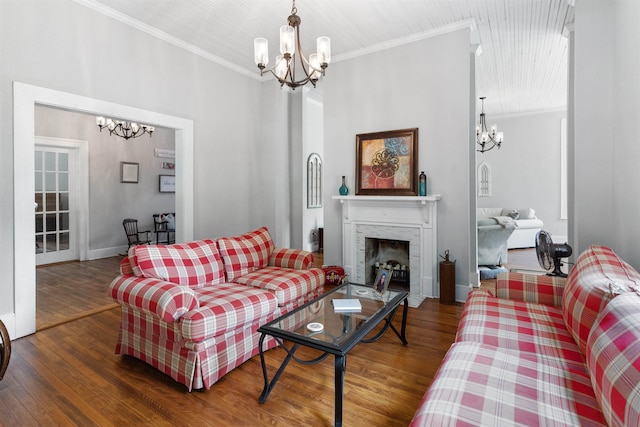 living room with a notable chandelier, crown molding, and dark wood-type flooring