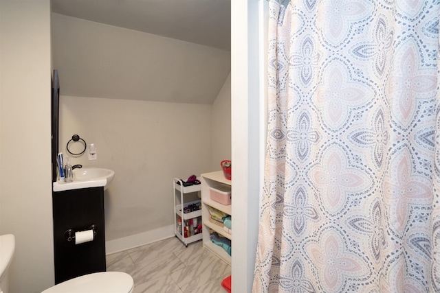 bathroom featuring vanity, curtained shower, lofted ceiling, and toilet