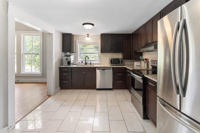 kitchen with tasteful backsplash, sink, dark brown cabinetry, and appliances with stainless steel finishes