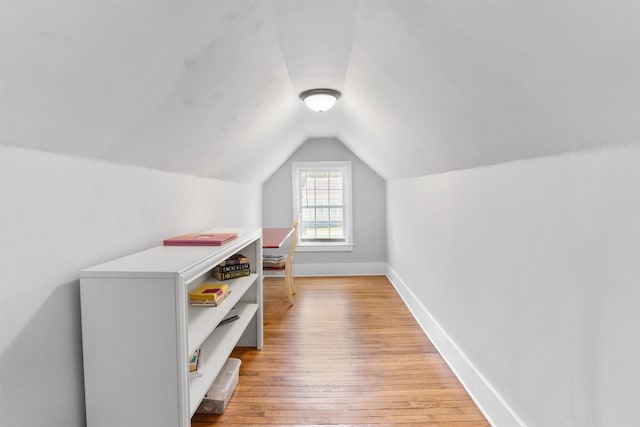 additional living space featuring lofted ceiling and light hardwood / wood-style floors