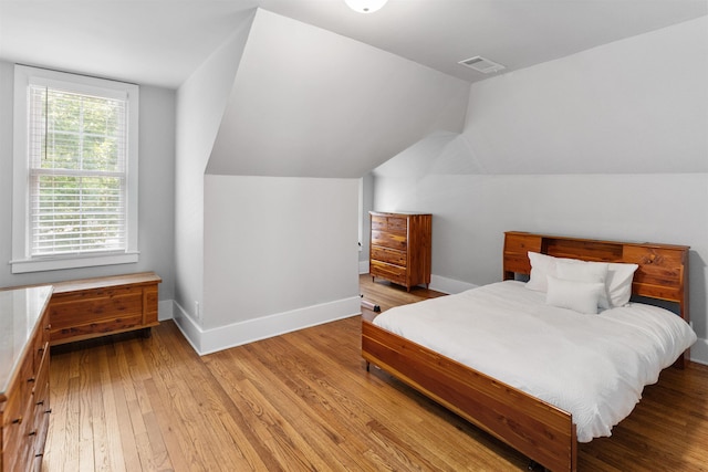 bedroom featuring vaulted ceiling and light hardwood / wood-style floors