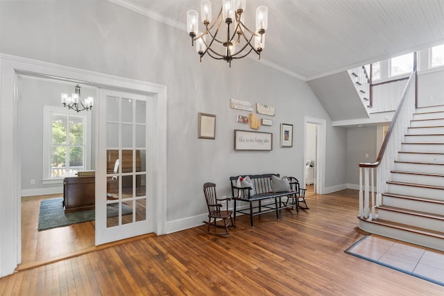 living area featuring vaulted ceiling, crown molding, dark hardwood / wood-style flooring, and a chandelier