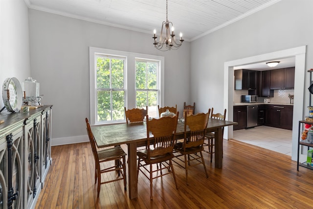 dining room featuring crown molding, an inviting chandelier, and light hardwood / wood-style floors