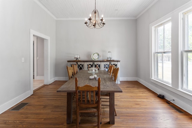 dining room featuring an inviting chandelier, hardwood / wood-style flooring, plenty of natural light, and crown molding