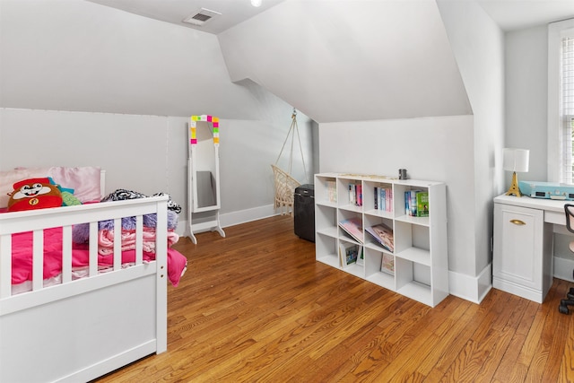 bedroom with vaulted ceiling and light wood-type flooring