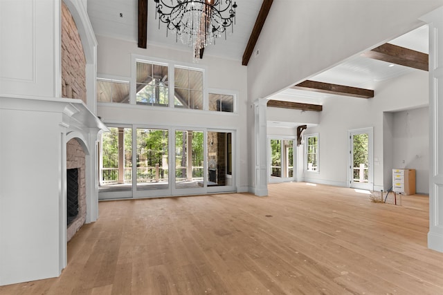 1111 Swift Crk, Greensboro, GA 30642 - unfurnished living room with high vaulted ceiling, beam ceiling, wood-type flooring, a fireplace, and a chandelier