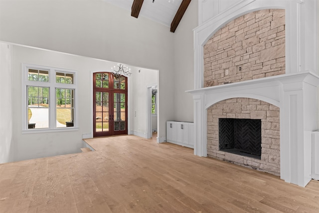1111 Swift Crk, Greensboro, GA 30642 - unfurnished living room featuring beamed ceiling, high vaulted ceiling, wood finished floors, a chandelier, and a fireplace