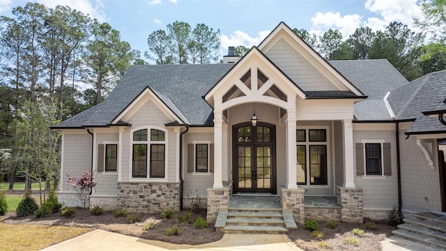 1111 Swift Crk, Greensboro, GA 30642 - view of front of house featuring french doors, a shingled roof, a chimney, and stone siding