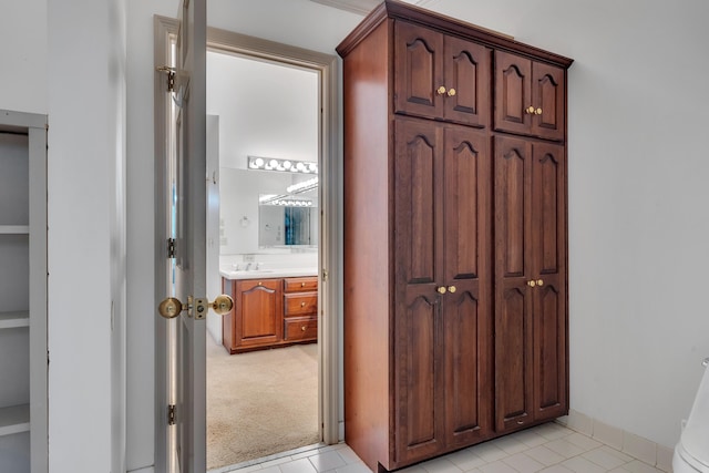 hallway featuring sink and light colored carpet