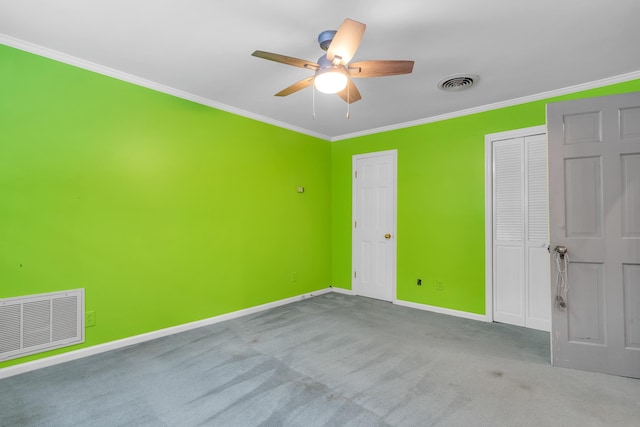 carpeted empty room featuring crown molding and ceiling fan