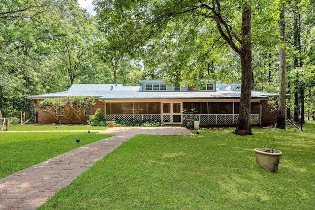 view of front of property featuring a front yard and a sunroom