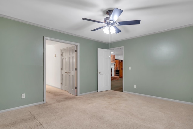 spare room with crown molding, light colored carpet, and ceiling fan