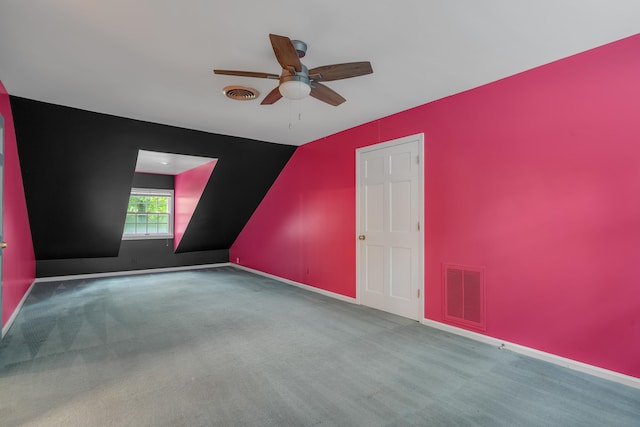 carpeted empty room featuring ceiling fan and vaulted ceiling