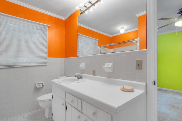 bathroom with tile walls, vanity, ceiling fan, toilet, and crown molding