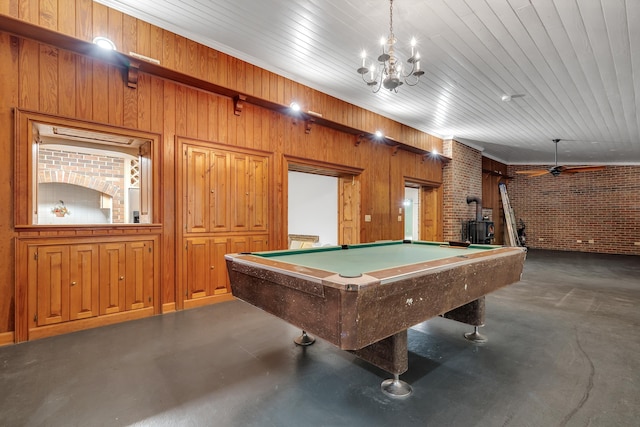 game room featuring pool table, brick wall, and a wood stove