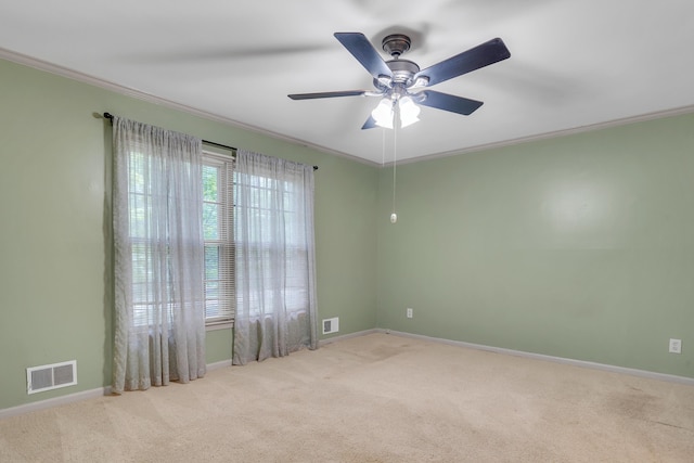 carpeted spare room with ornamental molding and ceiling fan