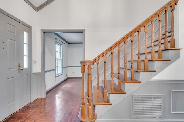 entryway featuring crown molding and dark parquet floors