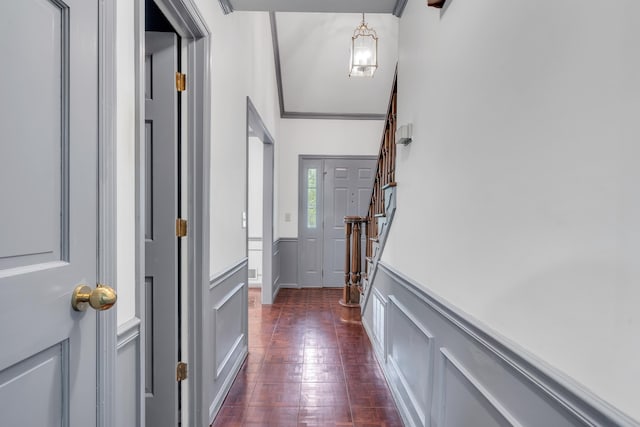 entryway with dark hardwood / wood-style flooring and crown molding