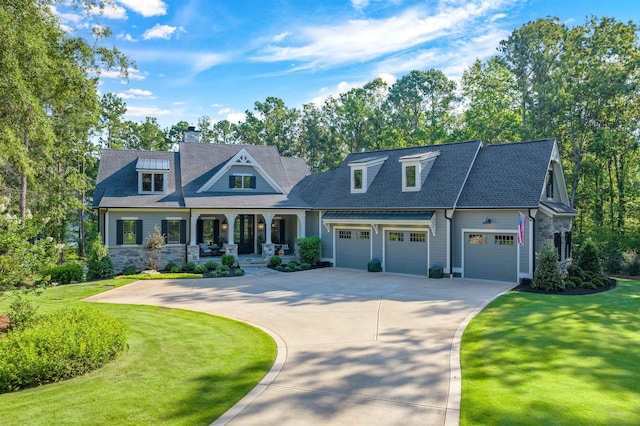 view of front of property featuring a porch, a garage, and a front lawn