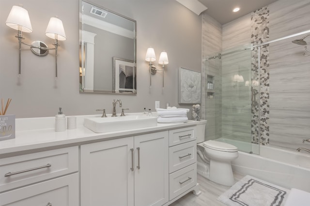 full bathroom featuring vanity, combined bath / shower with glass door, and toilet
