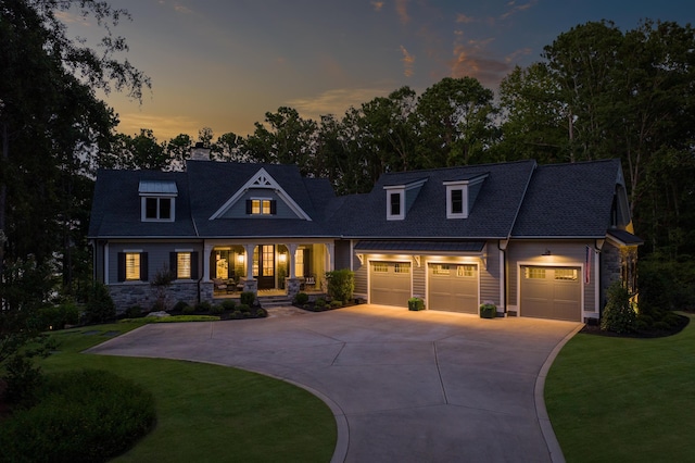 view of front of property with a garage, a porch, and a yard