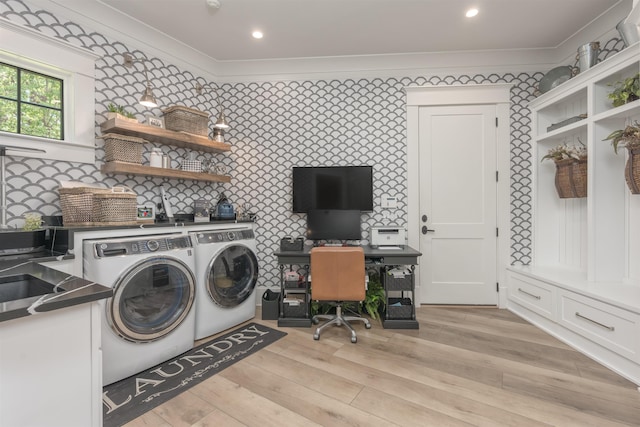laundry area with light hardwood / wood-style floors, sink, ornamental molding, and washer and dryer