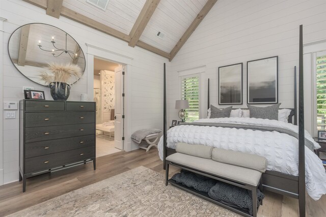 bedroom with connected bathroom, vaulted ceiling with beams, wood-type flooring, and wooden ceiling