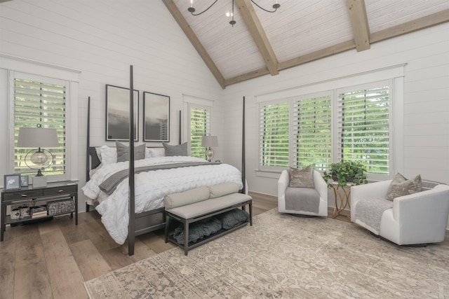 bedroom with beamed ceiling, hardwood / wood-style floors, and multiple windows
