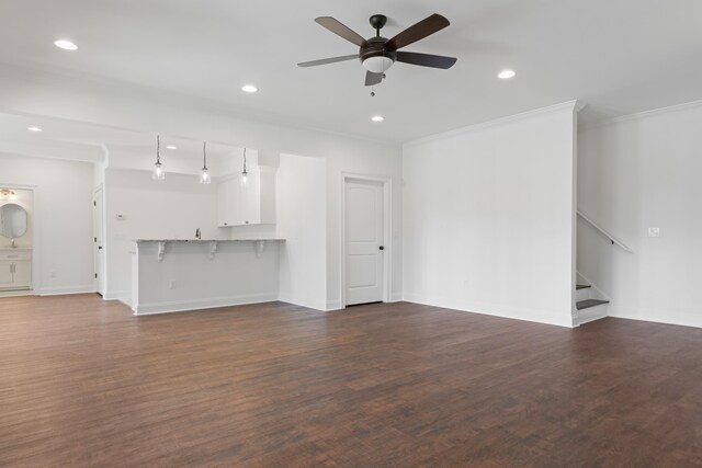 unfurnished living room with dark wood-type flooring, ornamental molding, and ceiling fan