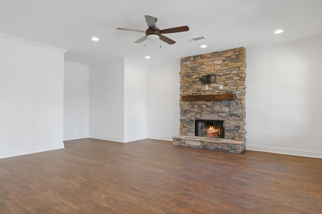 unfurnished living room featuring crown molding, a stone fireplace, ceiling fan, and dark hardwood / wood-style flooring