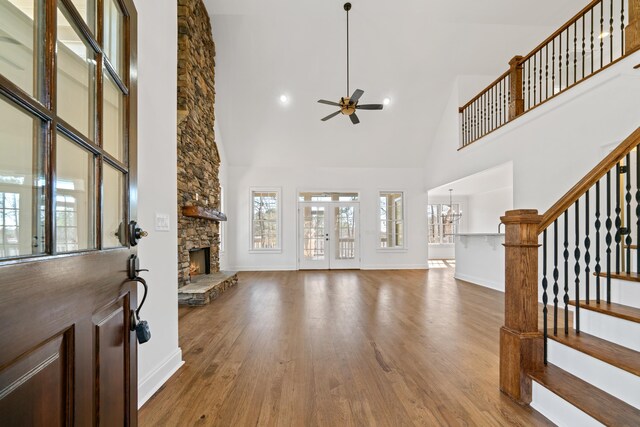 living room featuring hardwood / wood-style floors, ceiling fan with notable chandelier, plenty of natural light, and a fireplace