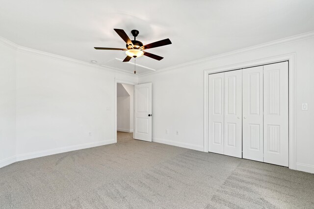 unfurnished bedroom with ornamental molding, light colored carpet, ceiling fan, and a closet