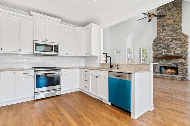 kitchen featuring sink, light hardwood / wood-style floors, white cabinets, and appliances with stainless steel finishes