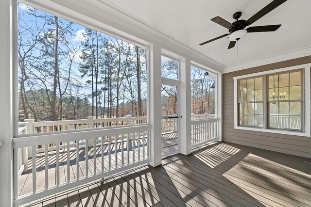 unfurnished sunroom with ceiling fan