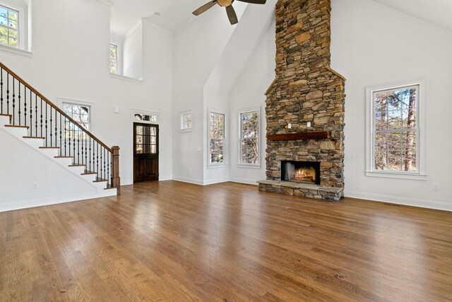 unfurnished living room featuring hardwood / wood-style flooring, plenty of natural light, and a stone fireplace