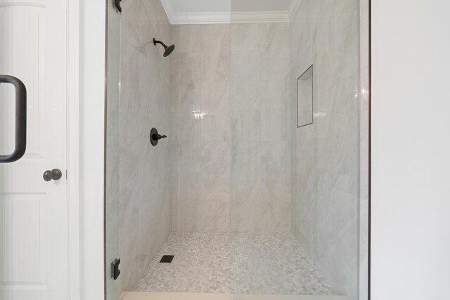 bathroom with ornamental molding and an enclosed shower