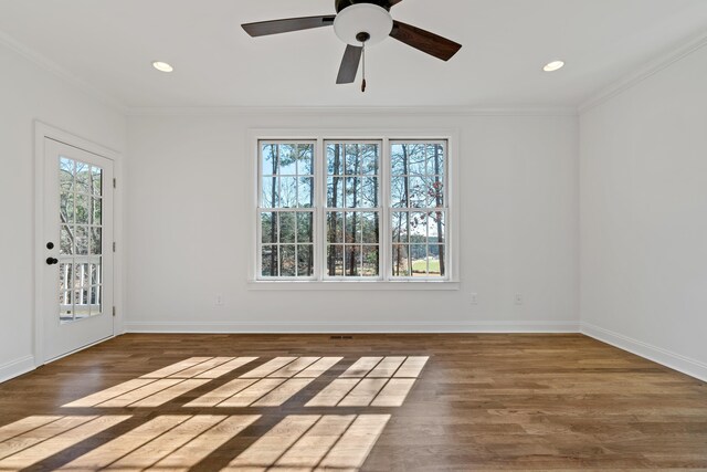 spare room with crown molding, plenty of natural light, and dark hardwood / wood-style floors