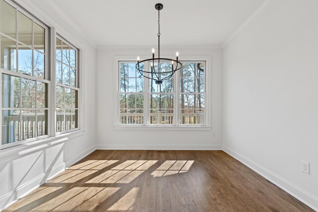 unfurnished dining area featuring crown molding, a chandelier, and dark hardwood / wood-style flooring