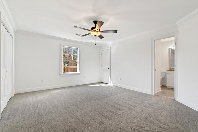 unfurnished bedroom with connected bathroom, ornamental molding, and light colored carpet