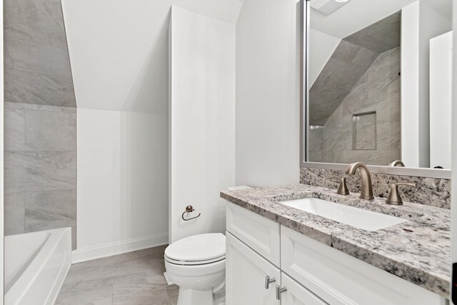 bathroom featuring vanity, vaulted ceiling, and toilet