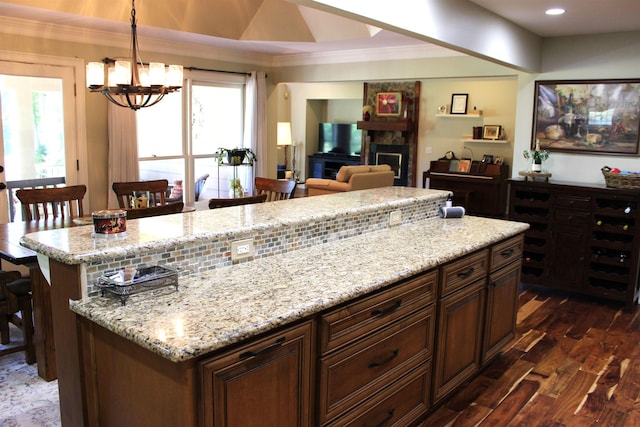 kitchen featuring hanging light fixtures, a kitchen island, dark wood-type flooring, and a kitchen breakfast bar