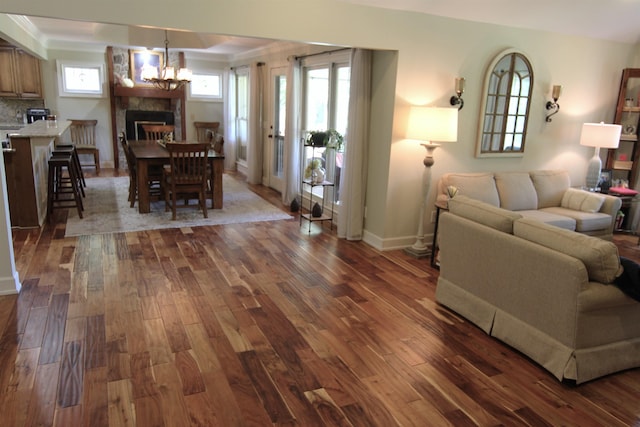 living room with ornamental molding, dark hardwood / wood-style floors, and a chandelier