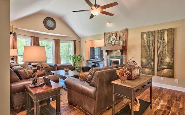 living room featuring a fireplace, wood-type flooring, ceiling fan, and vaulted ceiling