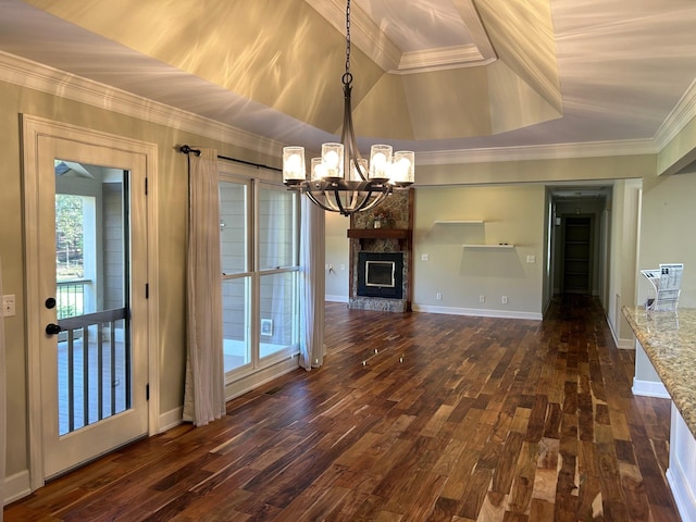 unfurnished living room featuring vaulted ceiling, dark hardwood / wood-style floors, a fireplace, a notable chandelier, and crown molding