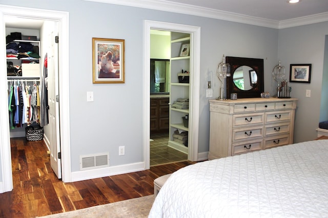 bedroom featuring ornamental molding, a spacious closet, dark hardwood / wood-style flooring, and a closet