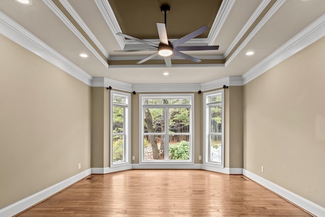 spare room with crown molding, a raised ceiling, and light hardwood / wood-style flooring