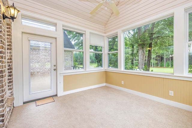 unfurnished sunroom featuring lofted ceiling, a healthy amount of sunlight, and ceiling fan