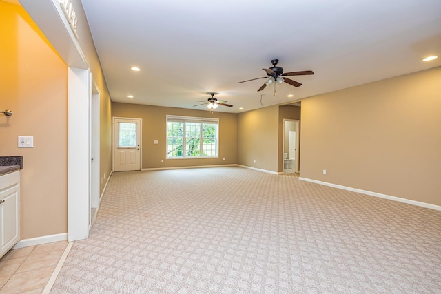 carpeted spare room with ceiling fan